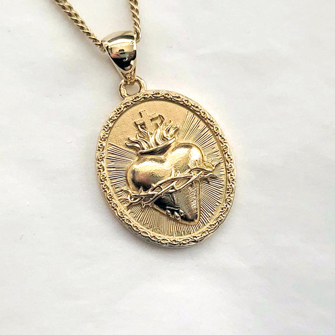 men's and women's sacred heart pendant necklace in 14k and 18k gold, with an oval shape